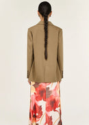 Woman wearing a beige blazer on a white background
