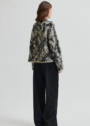 Woman wearing a patterned sweater on a plain background