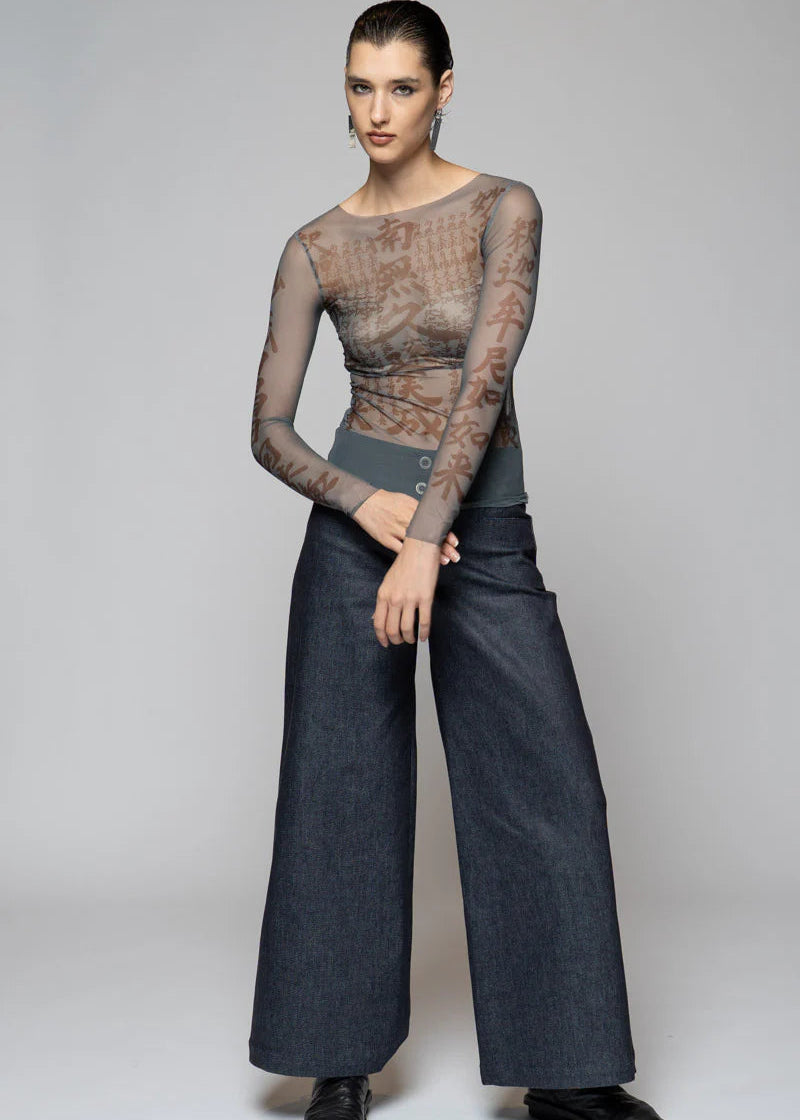 Woman wearing sheer top on light background