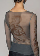 Woman wearing sheer top on light background