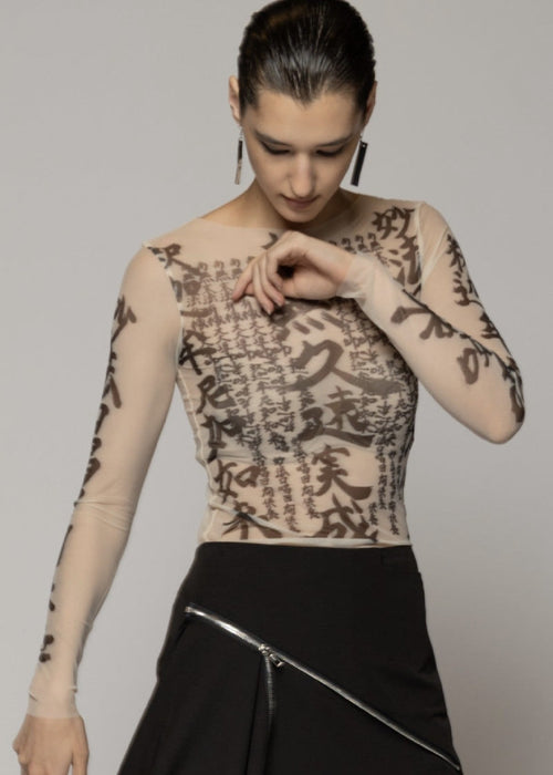 Woman wearing sheer top with dragon image on light background