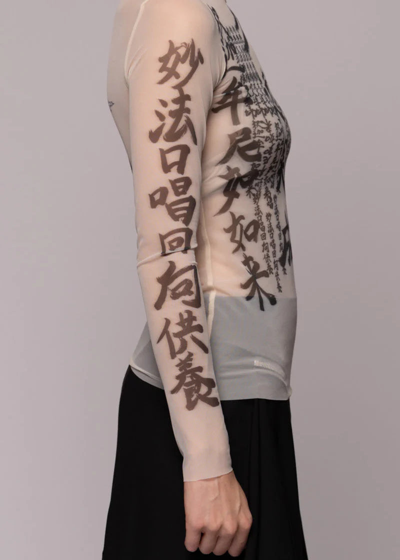 Woman wearing sheer top with dragon image on light background