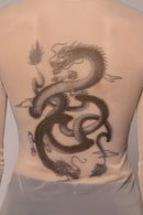 Woman wearing sheer top with dragon image on light background