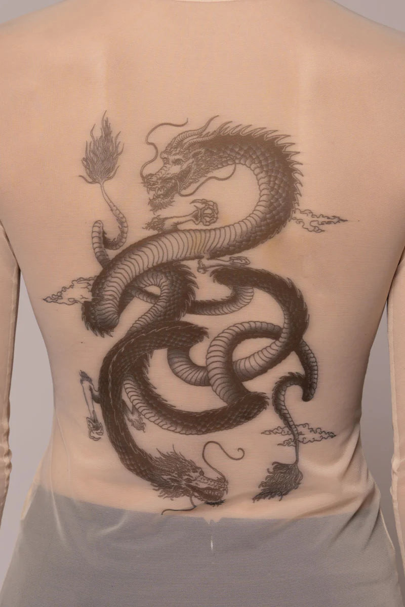 Woman wearing sheer top with dragon image on light background