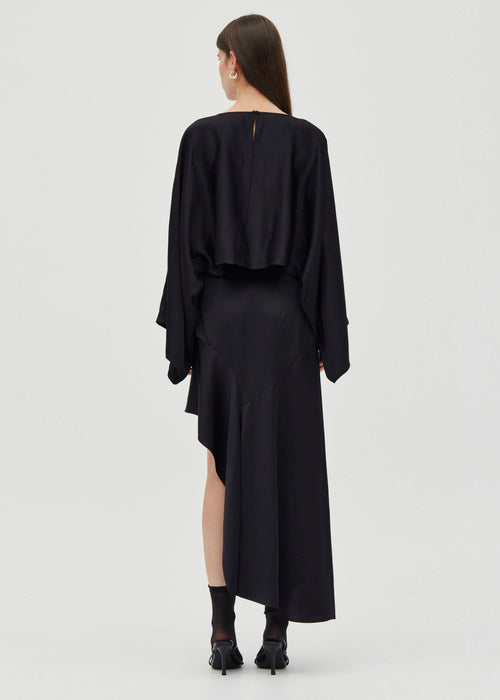 Black dress worn by a model on a white background