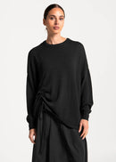 Woman wearing a black top against a white background