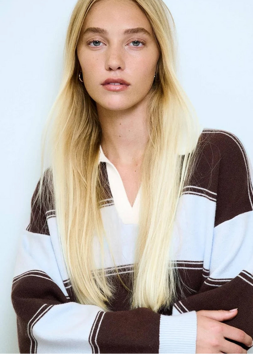 Woman wearing stripe jumper on blue background