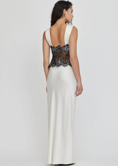 Woman wearing a black lace top and white skirt on a white background
