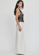 Woman wearing a black lace top and white skirt on a white background