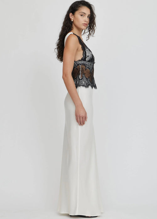 Woman wearing a black lace top and white skirt on a white background