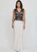 Woman wearing a black lace top and white skirt on a white background