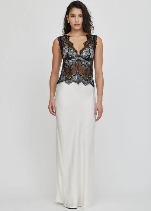 Woman wearing a black lace top and white skirt on a white background