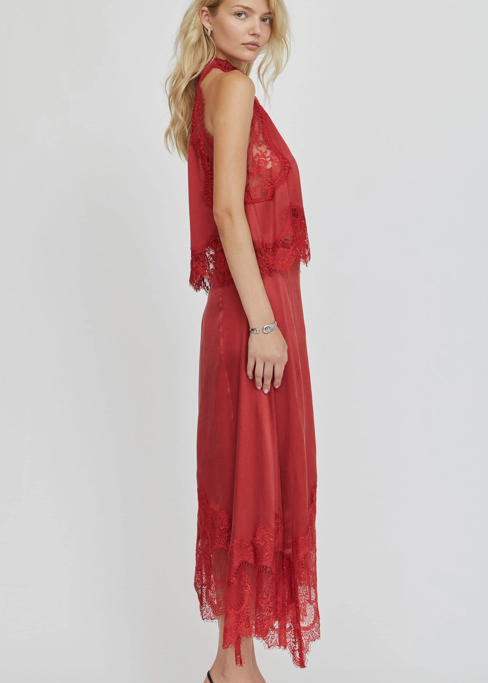 Woman wearing a red outfit with lace details on a white background