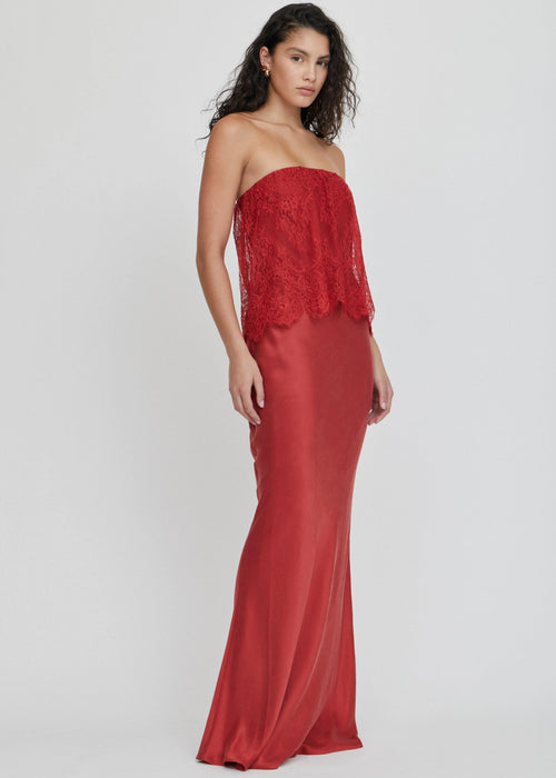 Woman wearing a red strapless dress on a white background