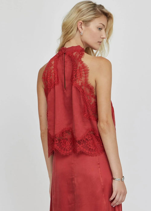 Woman wearing a red lace top on a white background