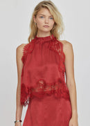 Woman wearing a red lace top on a white background