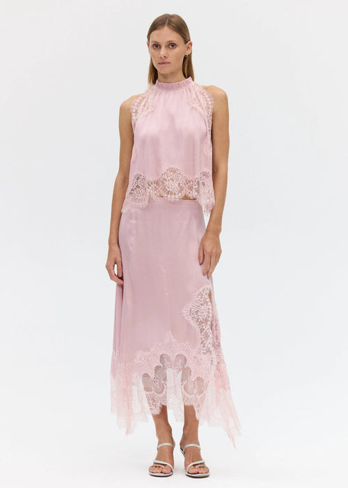 Woman wearing a pink lace top on a white background