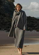 Woman wearing a grey skirt standing on the beach