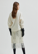 White lace skirt with black gloves on a white background