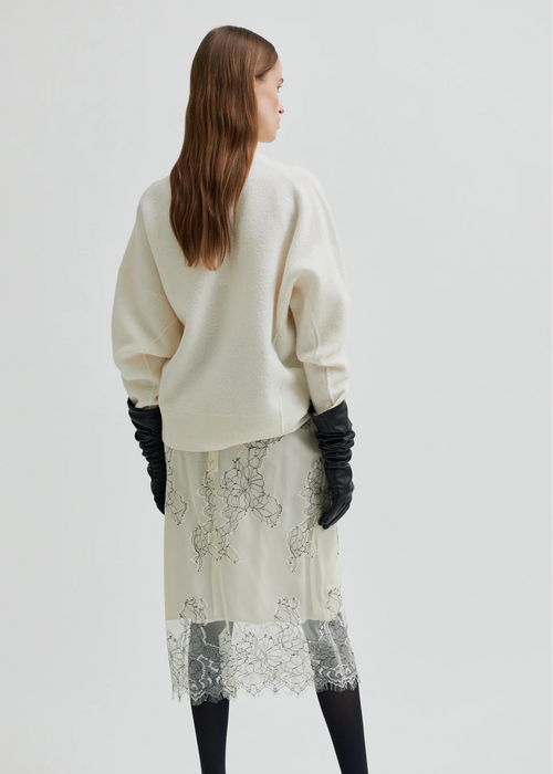 White lace skirt with black gloves on a white background