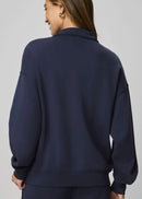Navy blue pullover with a quarter zip on a plain background