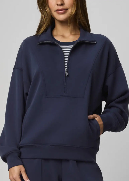 Navy blue pullover with a quarter zip on a plain background